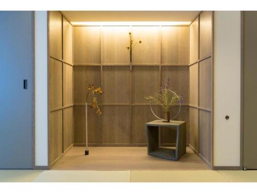 a room with a wall with a shelf with flowers on it at MUSUBI HOTEL KAMIGOFUKU-MACHI 1 - Vacation STAY 48031v in Hakata