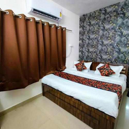 1 dormitorio con 2 camas y cortina en SR Elite Stays, en Jaipur