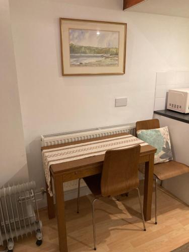 ein Klavier in einem Zimmer mit einem Tisch und einem Stuhl in der Unterkunft Studio Annexe with separate shower room in Broadhempston