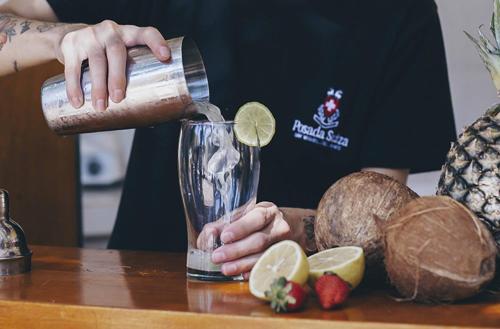 a woman is making a drink in a blender at Posada Suiza by Prima Collection in San Miguel del Monte