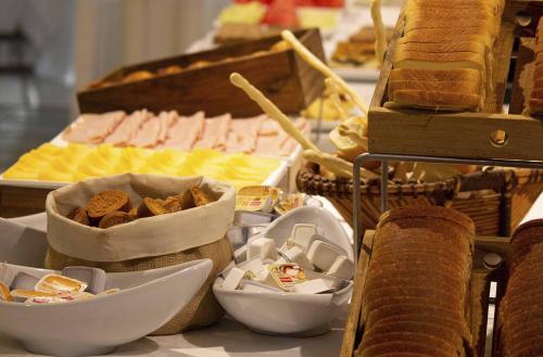 a buffet with bread and bowls of food on a table at Posada Suiza by Prima Collection in San Miguel del Monte