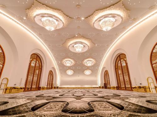 a large room with a ceiling with chandeliers at Raffles Doha in Doha