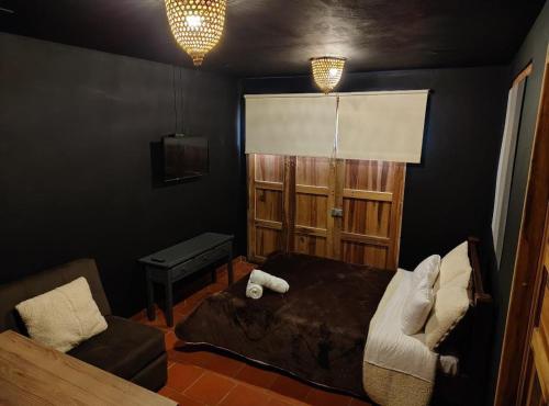 Un dormitorio con una cama y una silla y una ventana. en Zentroa habitación Senderos, en Villa de Leyva
