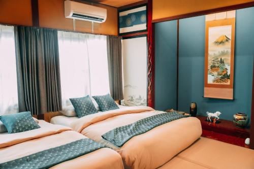 two beds in a room with blue walls and windows at Takayama - House - Vacation STAY 49009v in Takayama