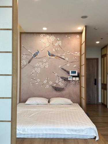 a bedroom with a bed with a painting on the wall at Sakura Room Ở Space Ecopark in Kim Quan