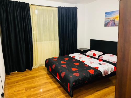 a bedroom with a bed with a black and red comforter at Apartament Soseaua Stefan cel mare in Bucharest