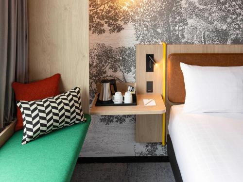 a bedroom with a bed and a side table at ibis Styles Copenhagen Orestad in Copenhagen