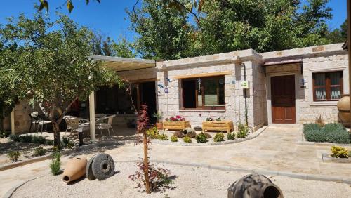 a stone house with a patio and a yard at Yıldız Hotel in Urgup