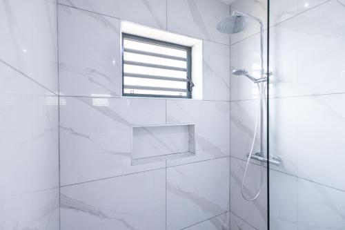 Un baño blanco con ducha y ventana. en Mambo One B, en Willemstad
