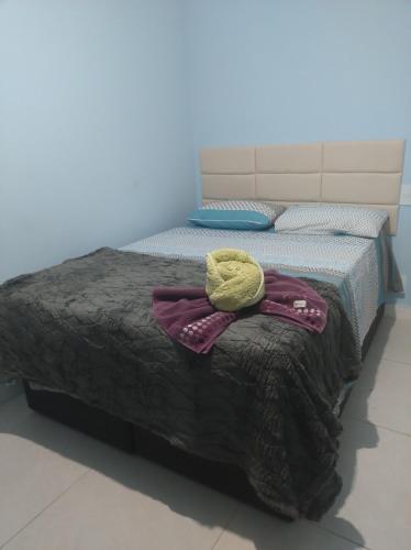 a bed with a blanket and a hat on it at Golden lake apartamento com linda vista para piscina in Arraial do Cabo