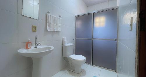 a bathroom with a toilet and a sink and a shower at Pousada S&K 