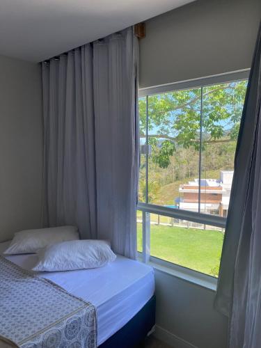 a bedroom with two beds and a large window at EuroPark no centro para casais e famílias, 800M da rua do lazer - incrível vista das montanhas in Domingos Martins