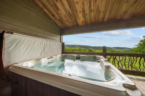 a bath tub sitting on a deck with a view at Overlook at Wilderness Trail in Newland
