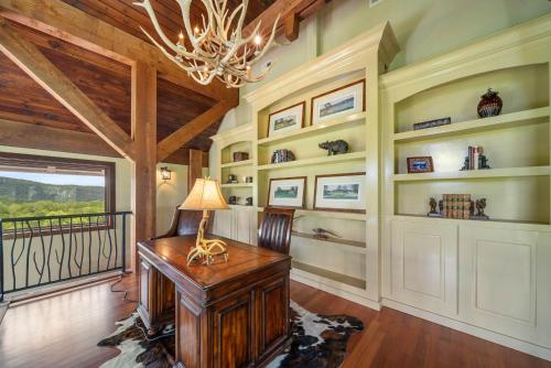 a home office with a wooden desk and a chandelier at Overlook at Wilderness Trail in Newland