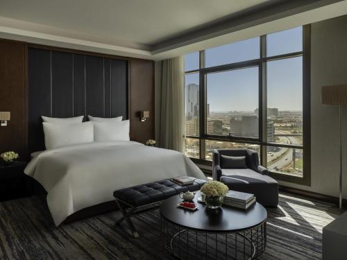 Una habitación de hotel con una cama y una ventana grande. en Movenpick Hotel and Residences Riyadh, en Riad