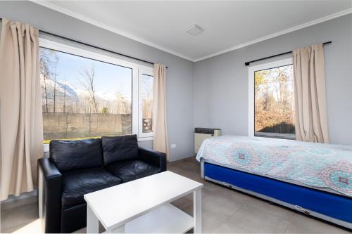 une chambre avec un lit, un canapé et une fenêtre dans l'établissement Complejo Turistico Paralelo 42, à Lago Puelo