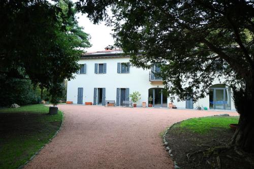 a large white house with a large driveway at La Casa nel Bosco in Somma Lombardo