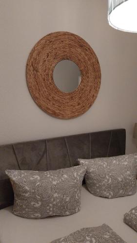 a wicker mirror on the wall above a couch at Beas Ferienglück in Busenberg