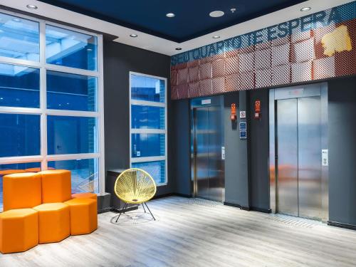 a lobby with orange chairs and a yellow chair at ibis budget Pindamonhangaba in Pindamonhangaba