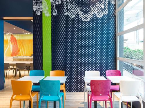 a group of tables and chairs in a restaurant at ibis budget Pindamonhangaba in Pindamonhangaba