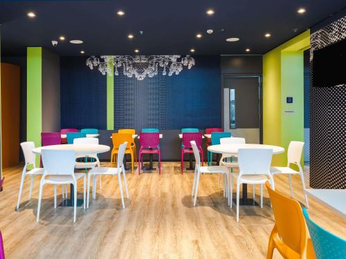 a dining room with tables and colorful chairs at ibis budget Pindamonhangaba in Pindamonhangaba