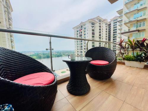 two wicker chairs and a table on a balcony at LoFF Suite River View 2 Bedroom at Kuching Riverine Resort in Kuching
