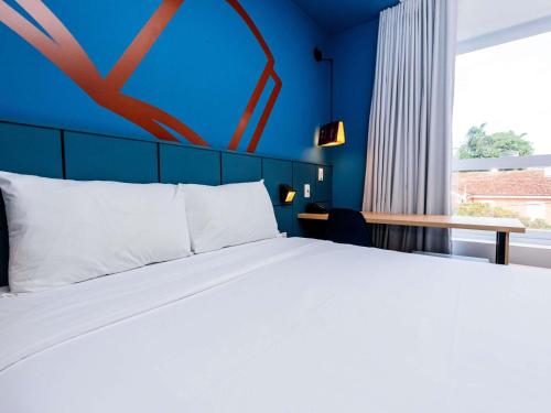 Una cama o camas en una habitación de ibis Styles Poços de Caldas