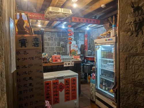 a kitchen with an open refrigerator in a restaurant at 芹壁望海樓民宿 in T'ung-ko