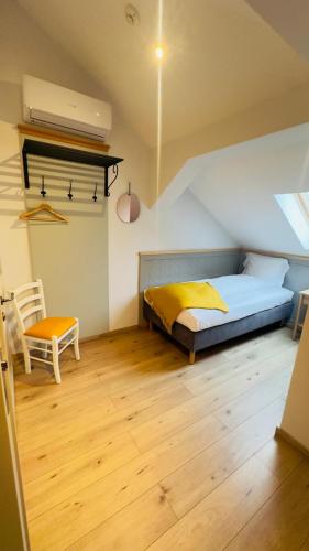 a bedroom with a bed and a chair in a room at Villa Piazzetta in Bacău