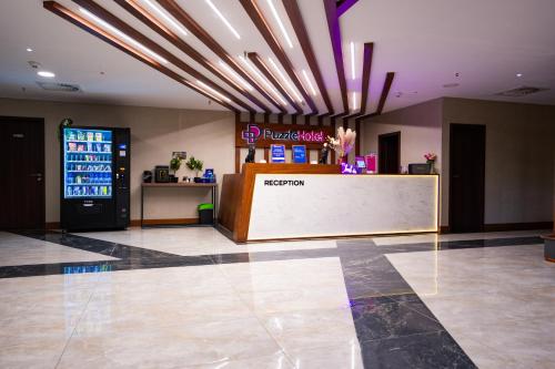 a store with a reception desk in a lobby at Puzzle Hotel Airport Frankfurt in Rüsselsheim