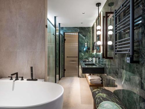 a bathroom with a tub and two sinks at Swissôtel Tbilisi in Tbilisi City