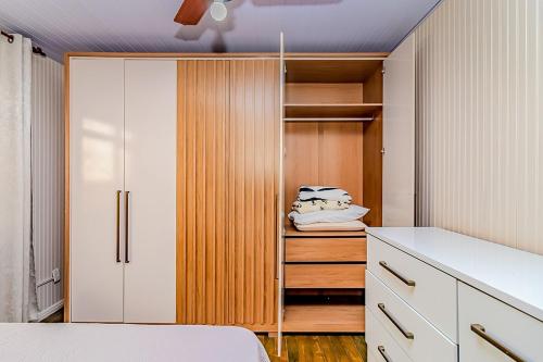 a bedroom with a closet with a bed and a cabinet at Casa Rosa Charmosa Completa BC Churrasco & Garagem in Balneário Camboriú
