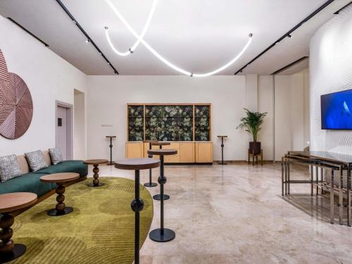 a room with tables and a couch and a television at Swissôtel Tbilisi in Tbilisi City