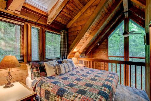 1 dormitorio con 1 cama en una cabaña con ventanas en The Dog House, en Boone