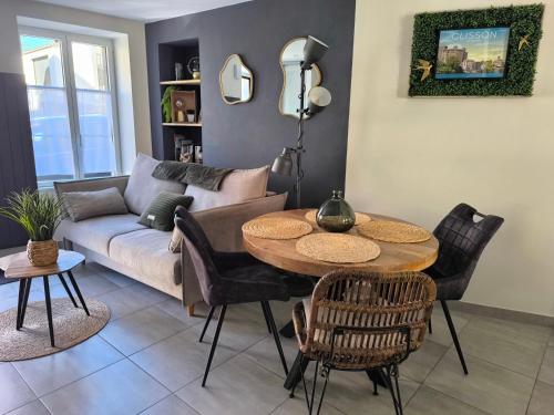 a living room with a table and a couch at Le P'Tivoli - Maison centre historique in Clisson