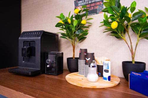 a desk with a coffee maker and a printer at Puzzle Hotel Airport Frankfurt in Rüsselsheim