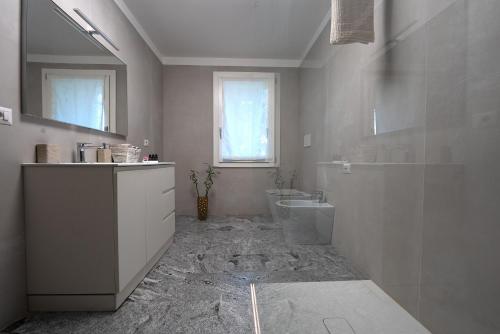 Un baño blanco con lavabo e inodoro. en Sybilvilla, en Oriago Di Mira