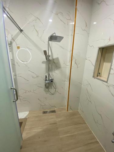 a bathroom with a shower with marble walls at Très beau appartement in Mostaganem