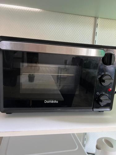 a microwave oven sitting on top of a shelf at O'Jade Vincent 2 I Parking I Wifi I Près de la gare in Orléans