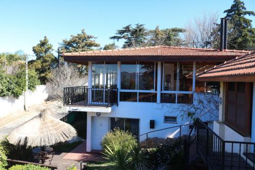 a house with a balcony and a patio at Costa Bonita Aparts & Spa in Villa Carlos Paz
