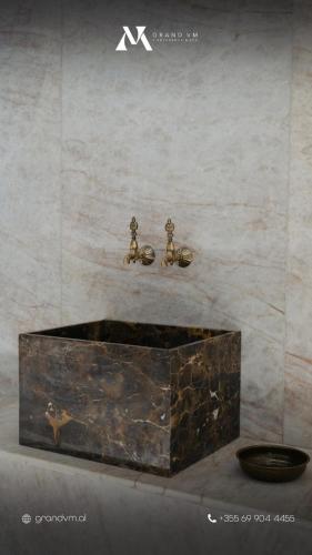 two figurines are sitting on a wall next to a box at Grand VM Conference & SPA in Golem