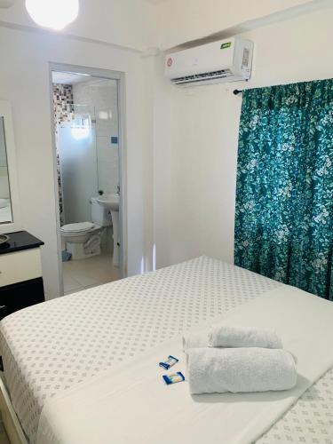 a bedroom with a bed with towels on it at Plataview Apartahotel apt 3A in Monte Plata