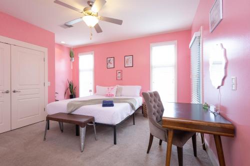 a bedroom with pink walls and a bed and a table at Lipstick & Boots 10 min to Broadway, Music Row, Fun in Nashville