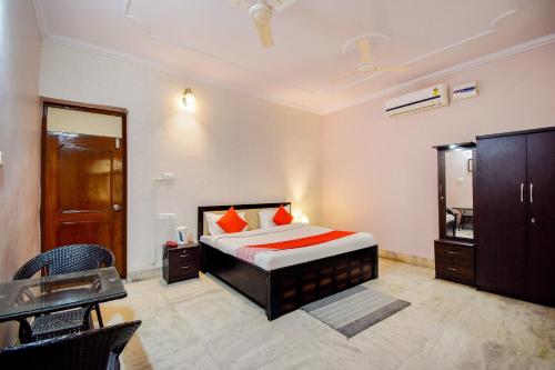 a bedroom with a bed and a dresser and a mirror at Hotel O The Nandini's Guest House in Jaipur