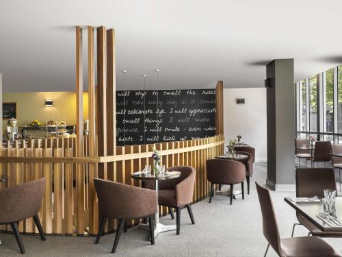 un restaurant avec des tables, des chaises et un tableau noir dans l'établissement Mantra on Kent, à Sydney