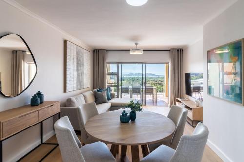 BRAND NEW Luxury Apartment with Ocean View في بليتنبيرغ باي: غرفة معيشة مع طاولة وكراسي