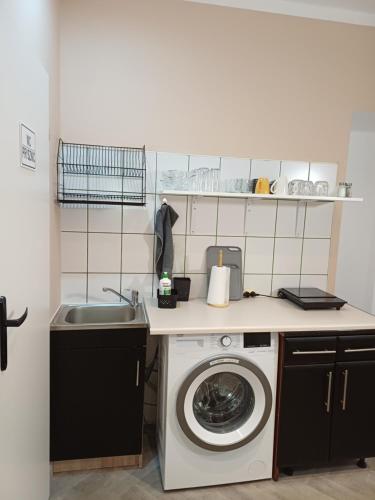 a kitchen with a washing machine and a sink at Rajca Room's - Pokoje przy Jasnej Górze in Częstochowa
