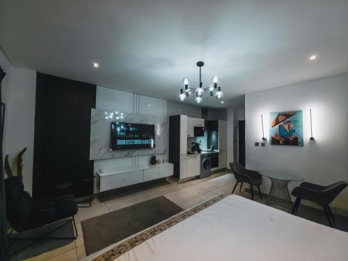 a bedroom with a bed and a table and chairs at Premium Studio Apartment, East Legon in Accra