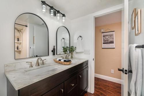 Un baño con lavabo y un espejo grande. en Elegant Ground Floor King Bed Condo - ME2, en Melbourne