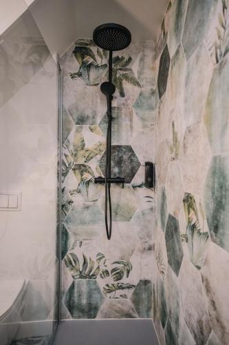 a shower in a bathroom with a stone wall at L'Amazone - Jungle Room avec Jacuzzi in Pont-du-Château